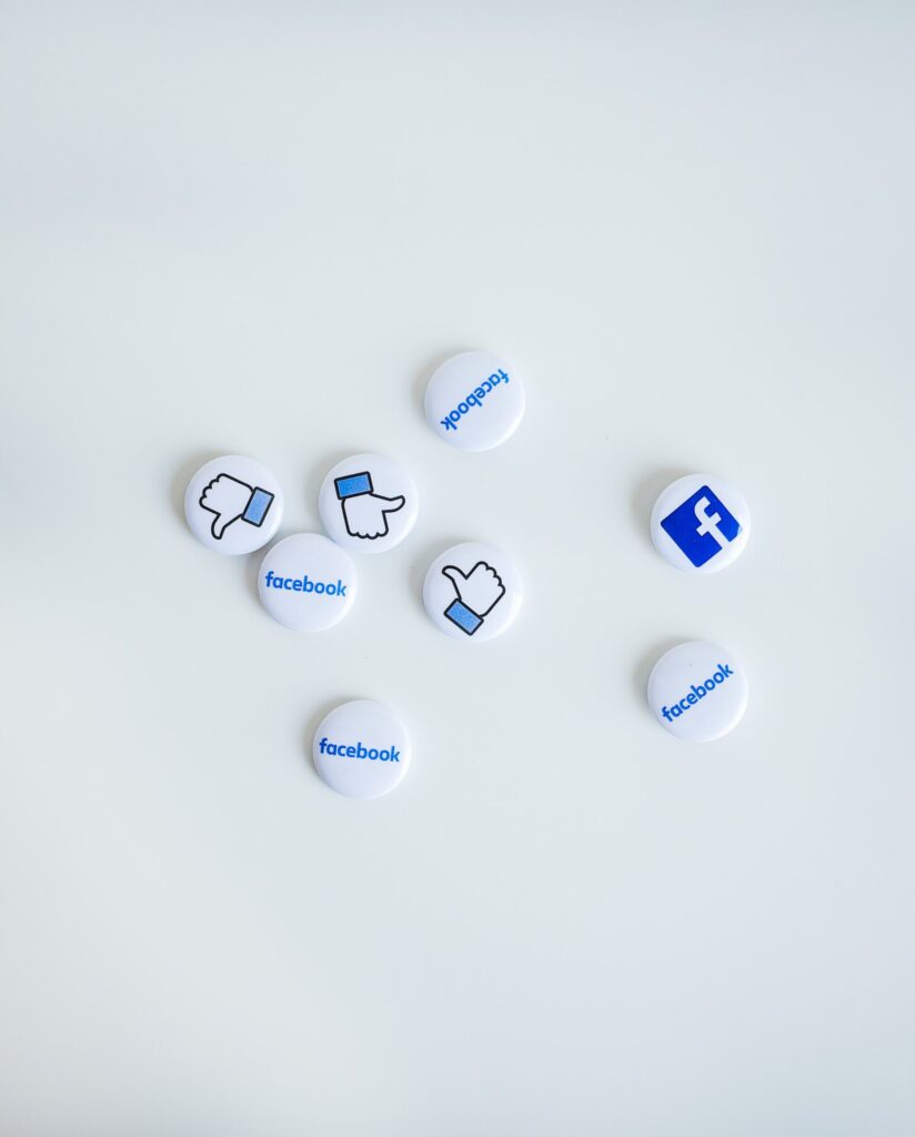Buttons with Facebook logo and thumbs up icon printed on them.