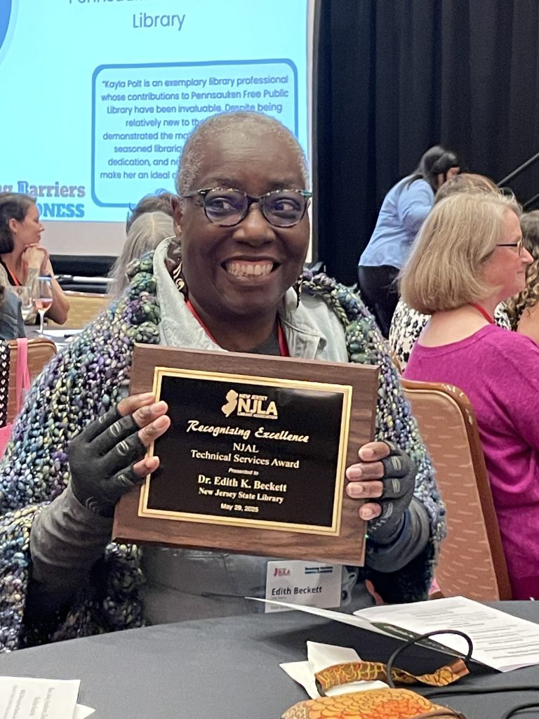 Dr. Edith Beckett with the NJAL Technical Services Award at NJLA at a table.