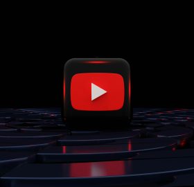 YouTube Red play logo illuminated in movie theater seating.