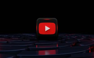 YouTube Red play logo illuminated in movie theater seating.