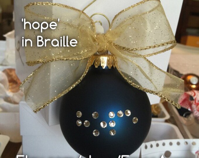 blue ornament saying hope in braille with a gold bow